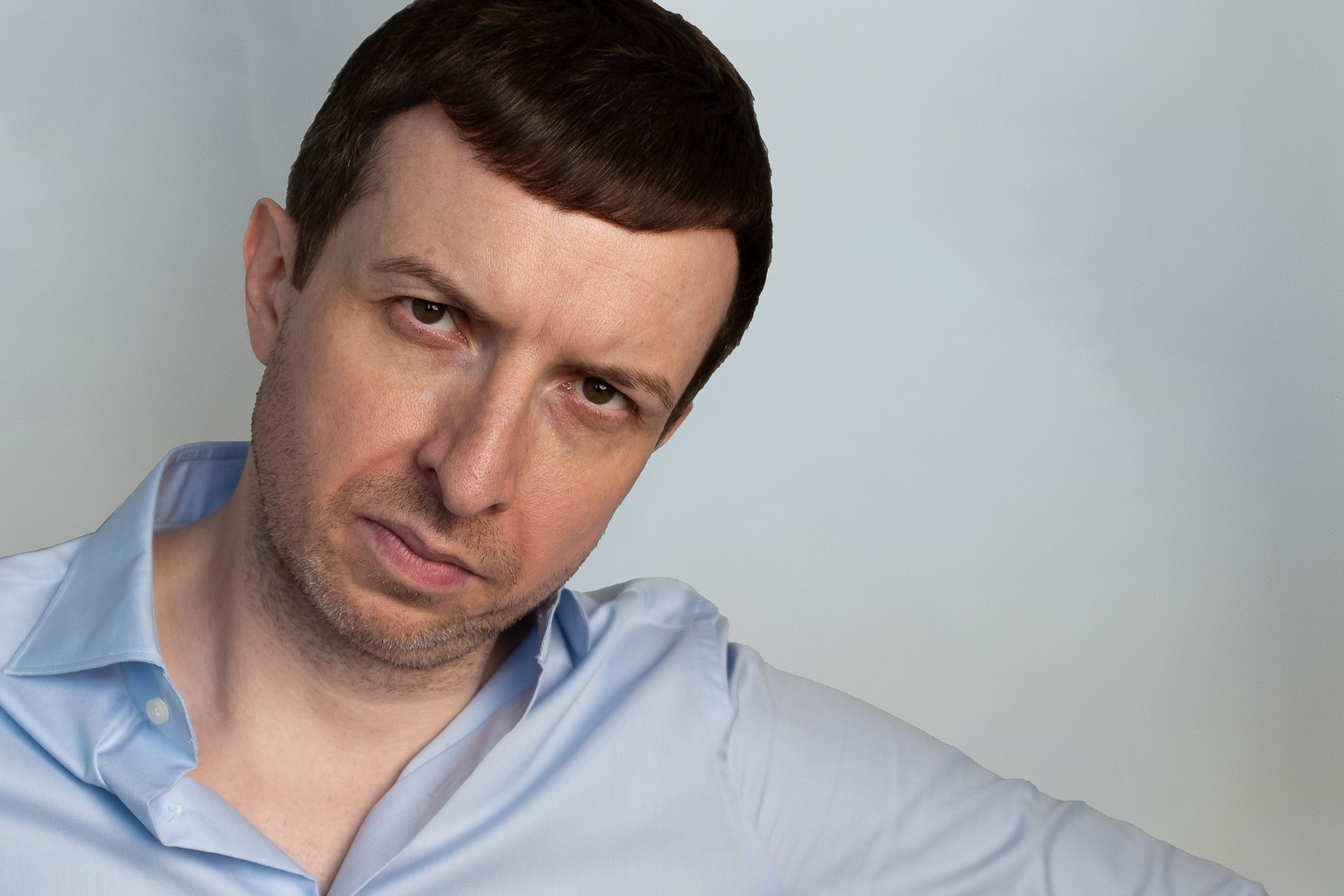 Michael Serwa - the best life coach in Europe, wearing a light blue shirt in his apartment in South Kensington, London